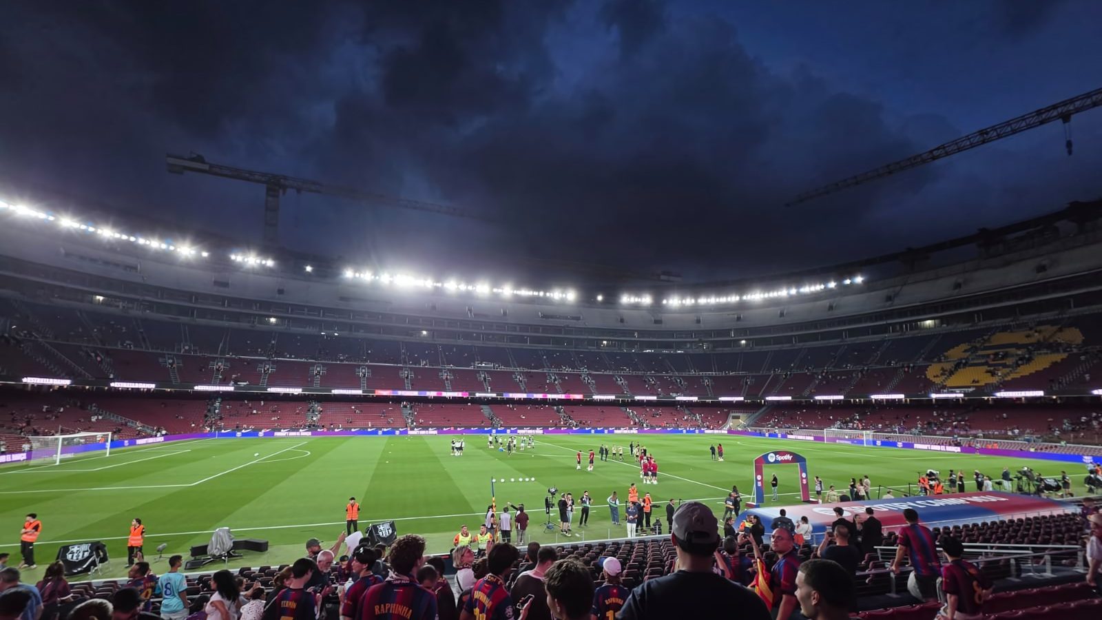 Hinchas del Barcelona en la tribuna del Spotify Camp Nou antes de un partido, con grúas de la remodelación sobre el estadio, septiembre de 2026