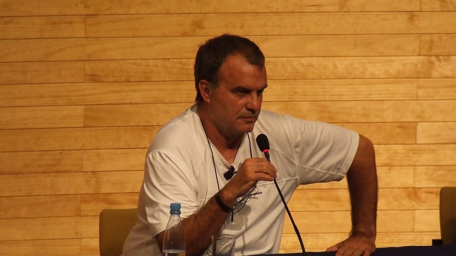Marcelo Bielsa, de remera blanca y con un micrófono, en una conferencia de prensa el 3 de marzo de 2009, cuando dirigía a Chile